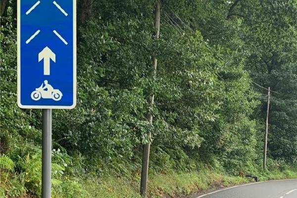 Arwydd glas a gwyn PRIME yn nodi ble dylai beicwyr modur reidio.