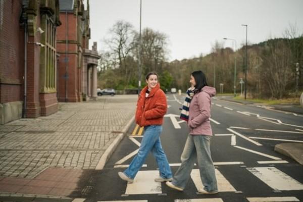 Two women on a road crossing