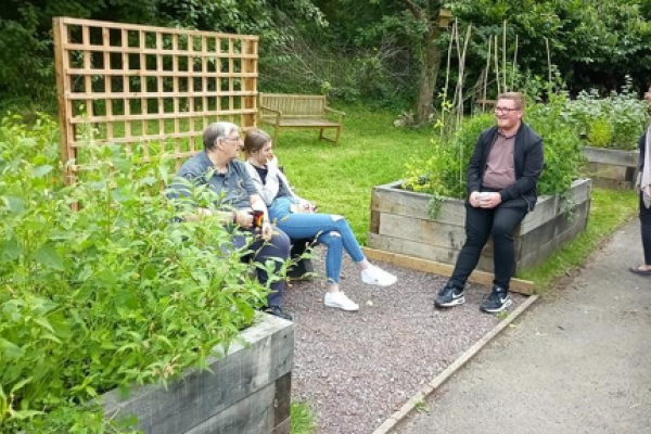 Gwirfoddolwyr BGfm o bob oedran yn adeiladu gwelyau uwch, plannu, a chynnal gardd gymunedol yn Nant-y-glo.